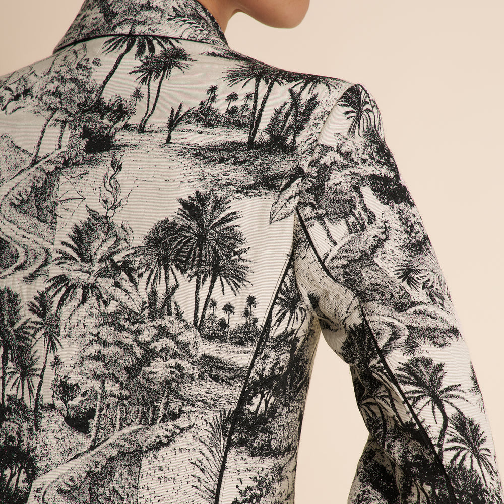 Close-up of a shirt with a black and white tropical pattern on a beige background