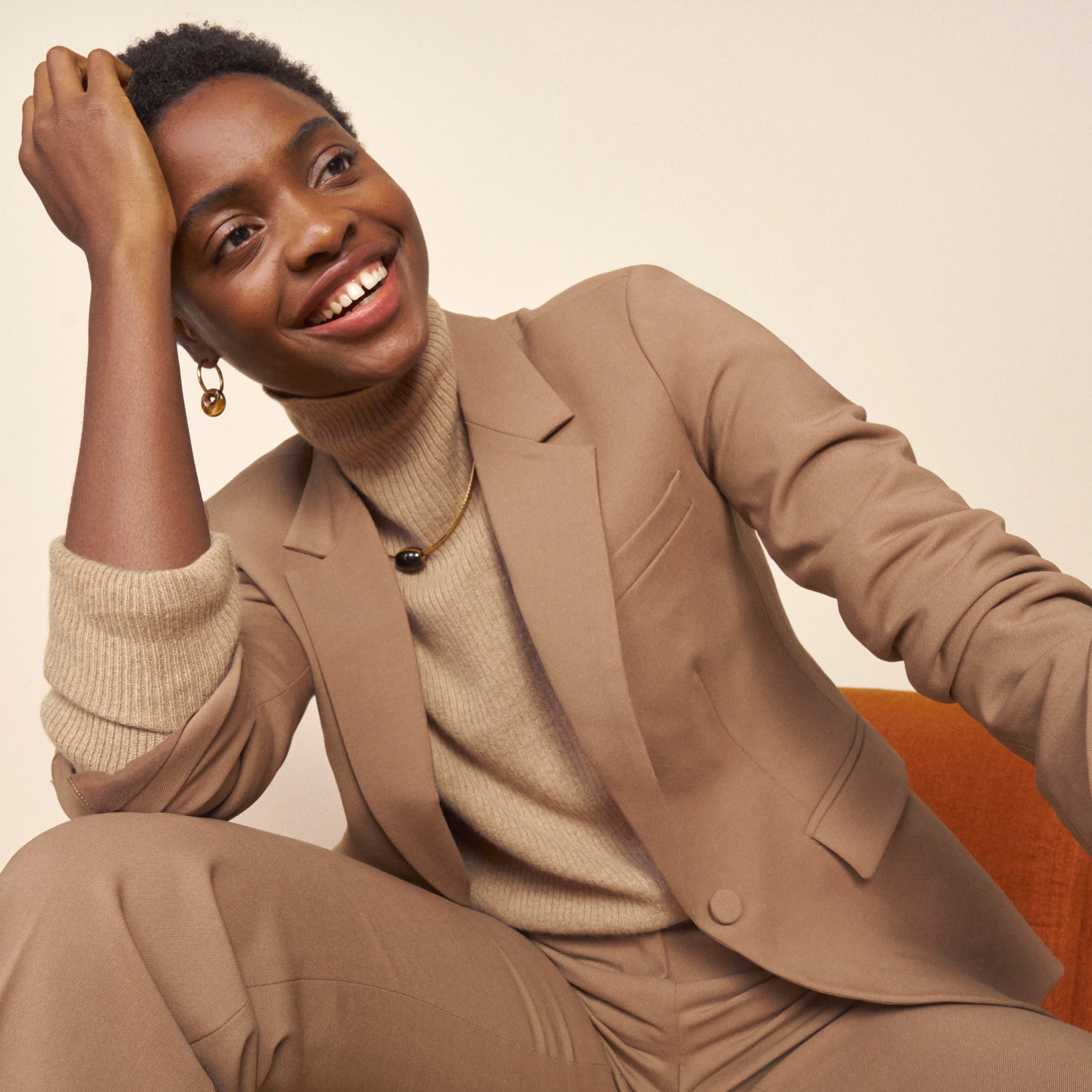 Front image of a woman standing wearing the Yiyan Blazer in Camel