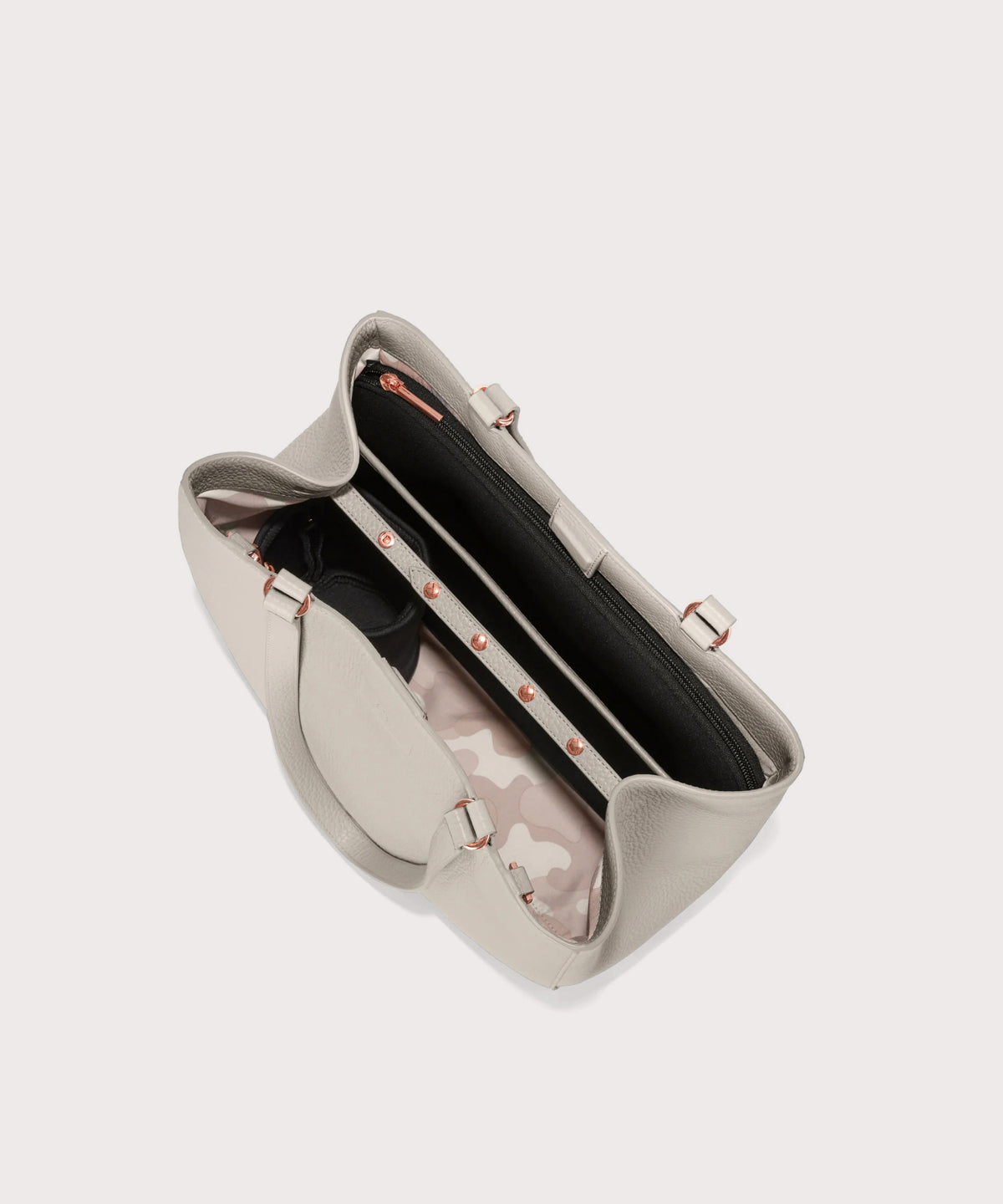 Open beige handbag with floral patterned lining on a light gray background