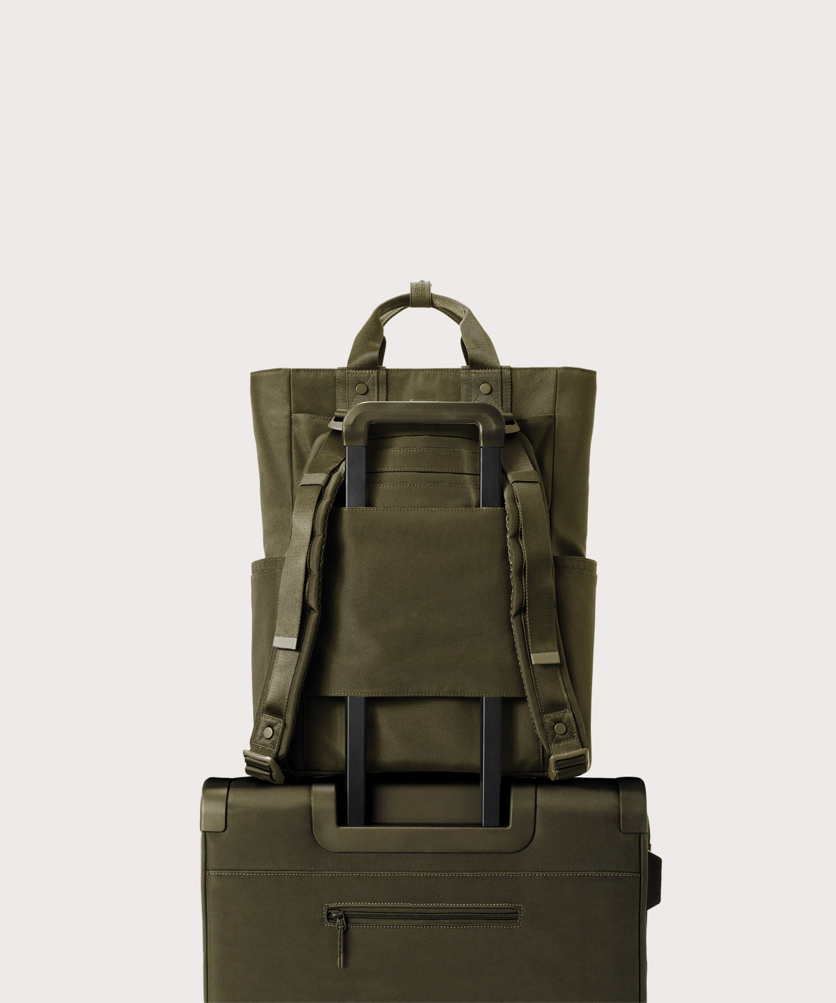 Two green backpacks stacked on a light gray background