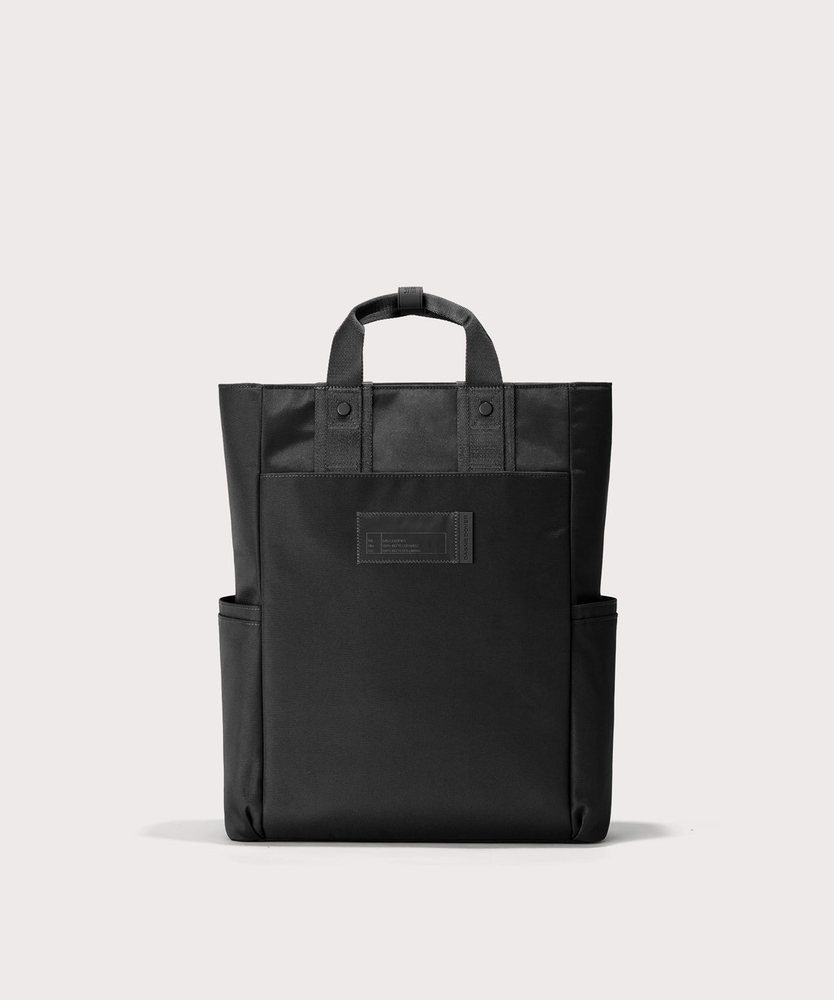 Black tote bag with a front pocket on a light gray background 