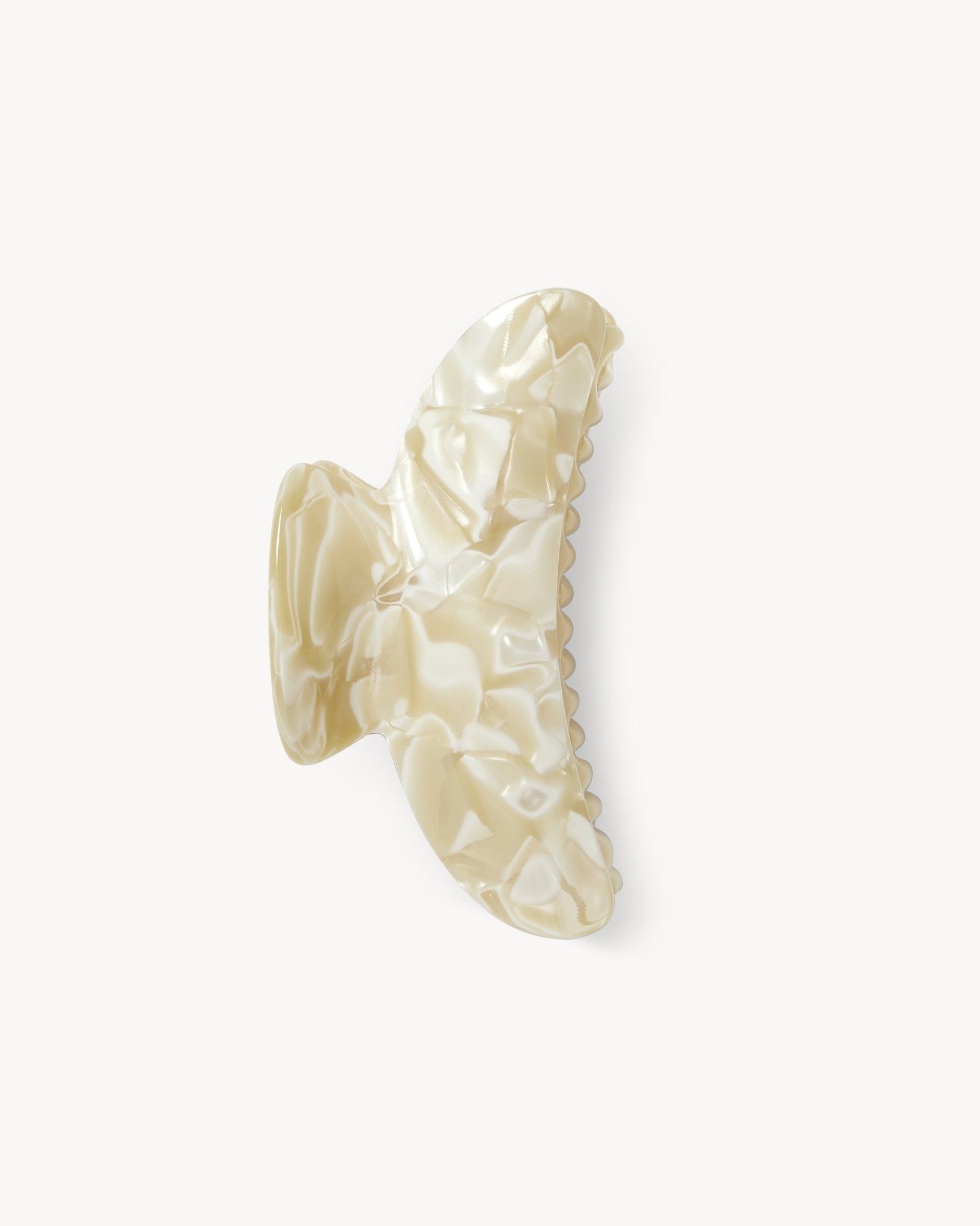 Beige hair clip with a textured pattern on a white background 