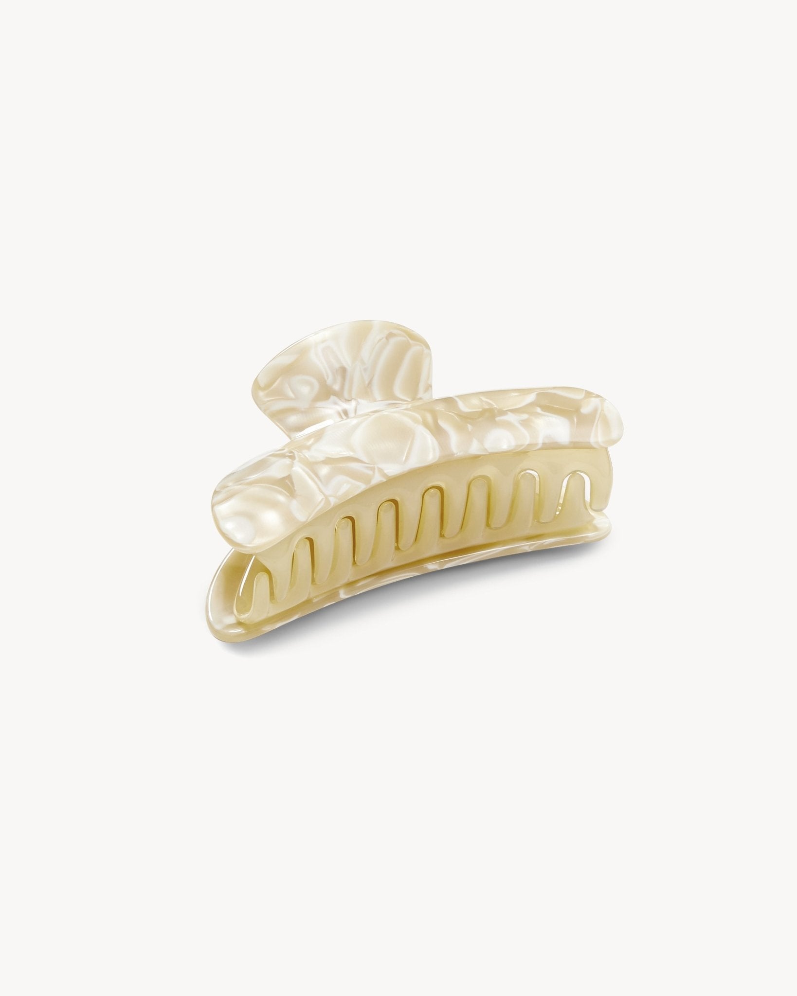 Gold hair clip with pearl-like stones on a white background
