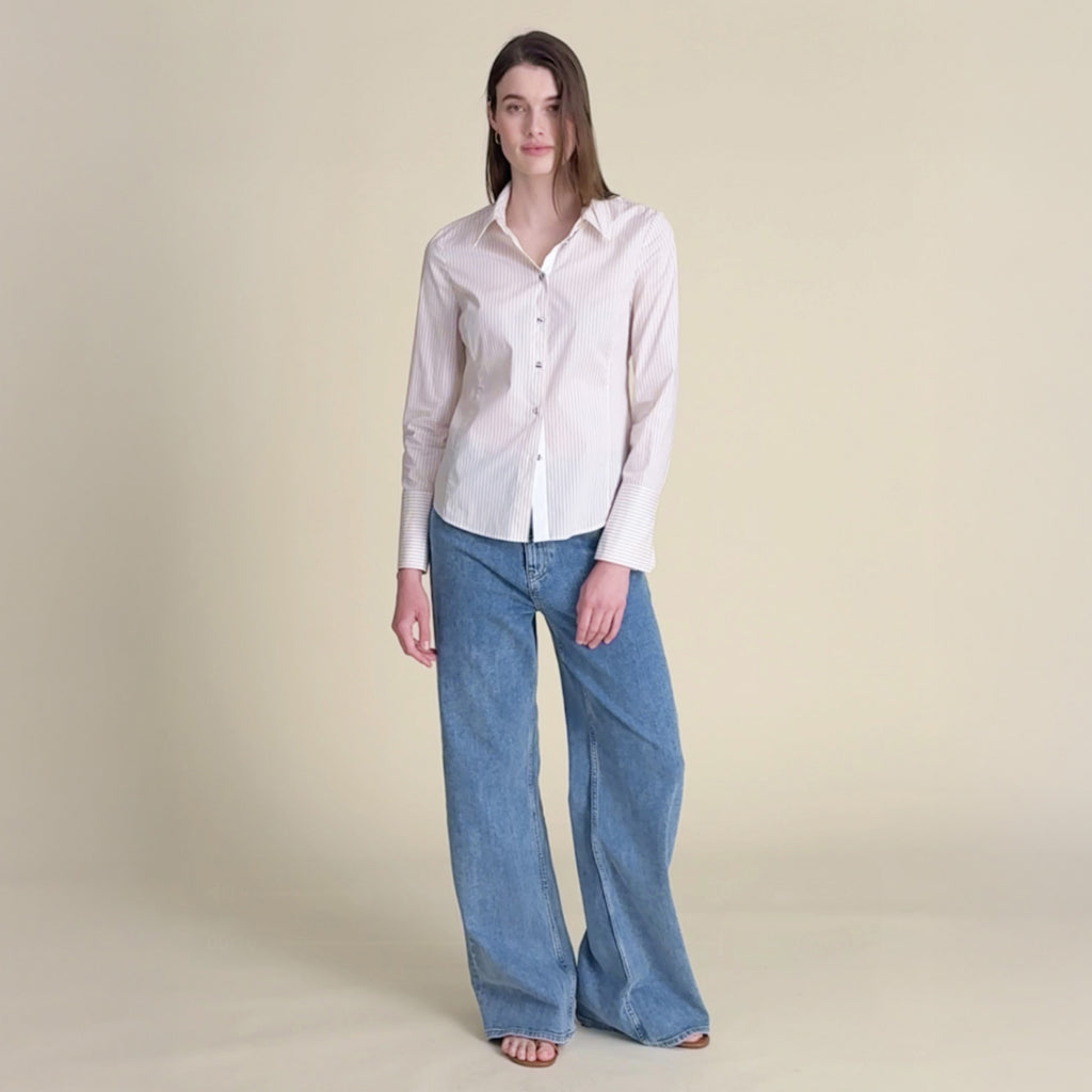 woman in striped button down with blue jeans.