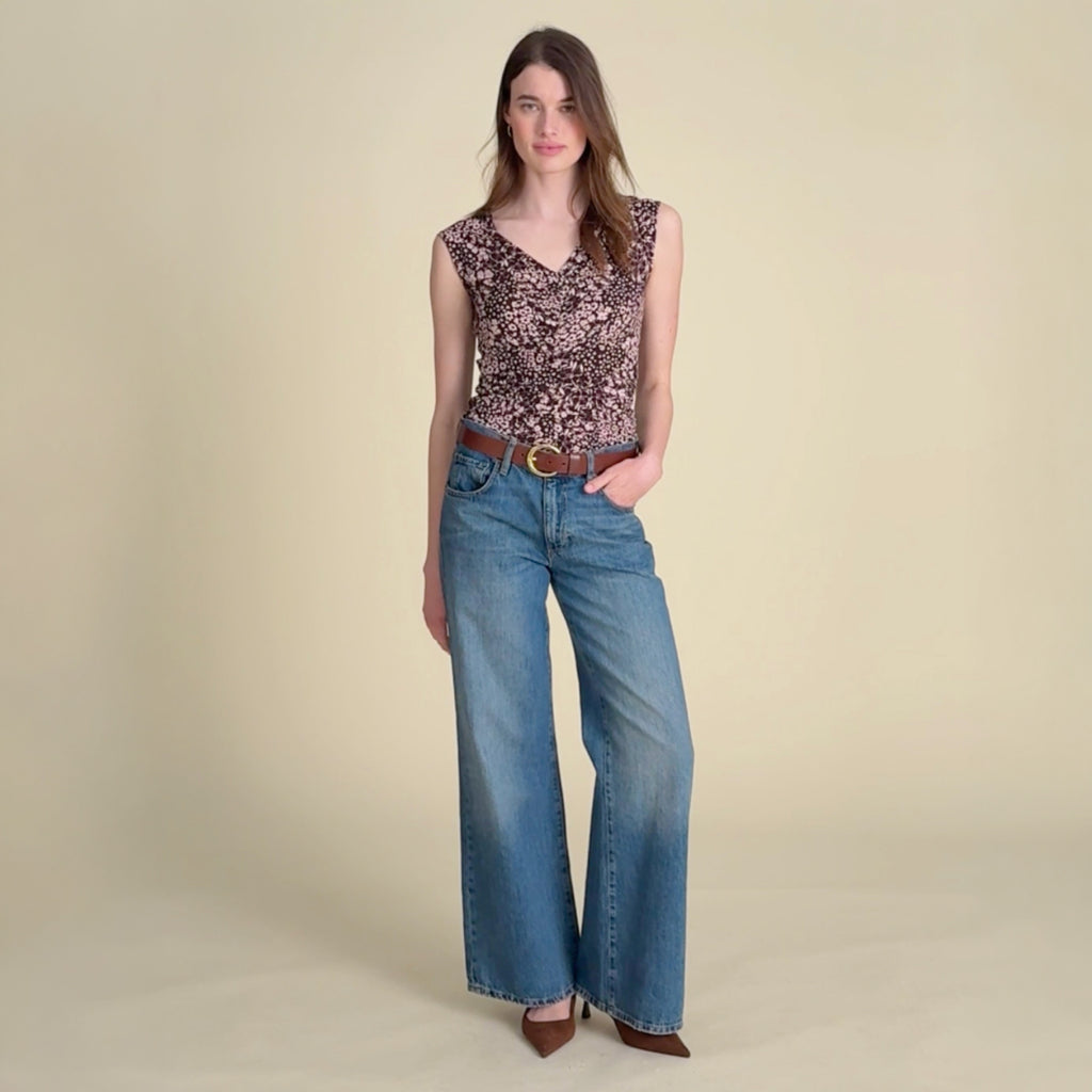 Video of a woman wearing a floral tank top and jeans