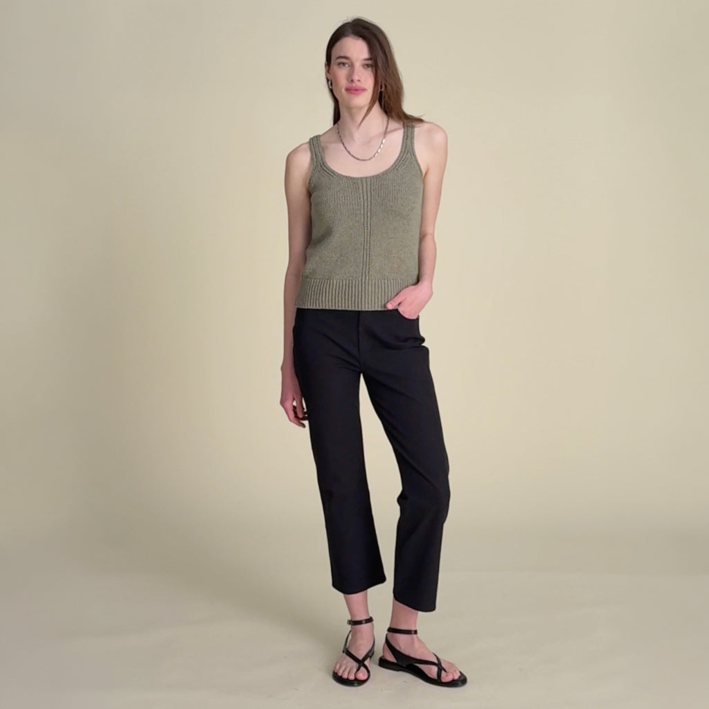 woman in green top with white jeans. 