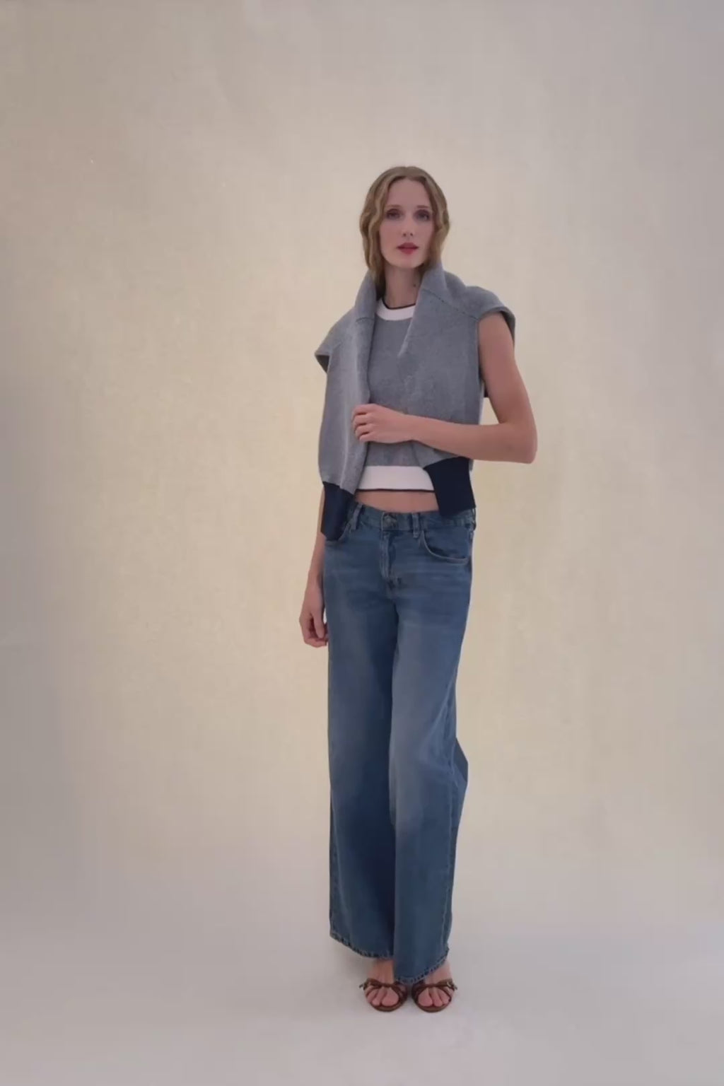 woman in sweater tank and blue jeans.