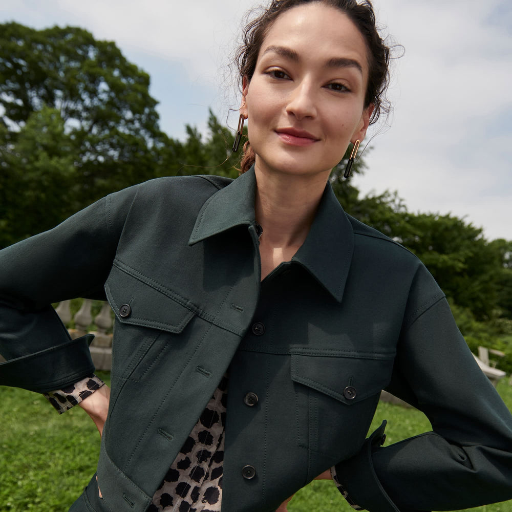 Front image of a woman standing wearing the anna jacket in hemlock