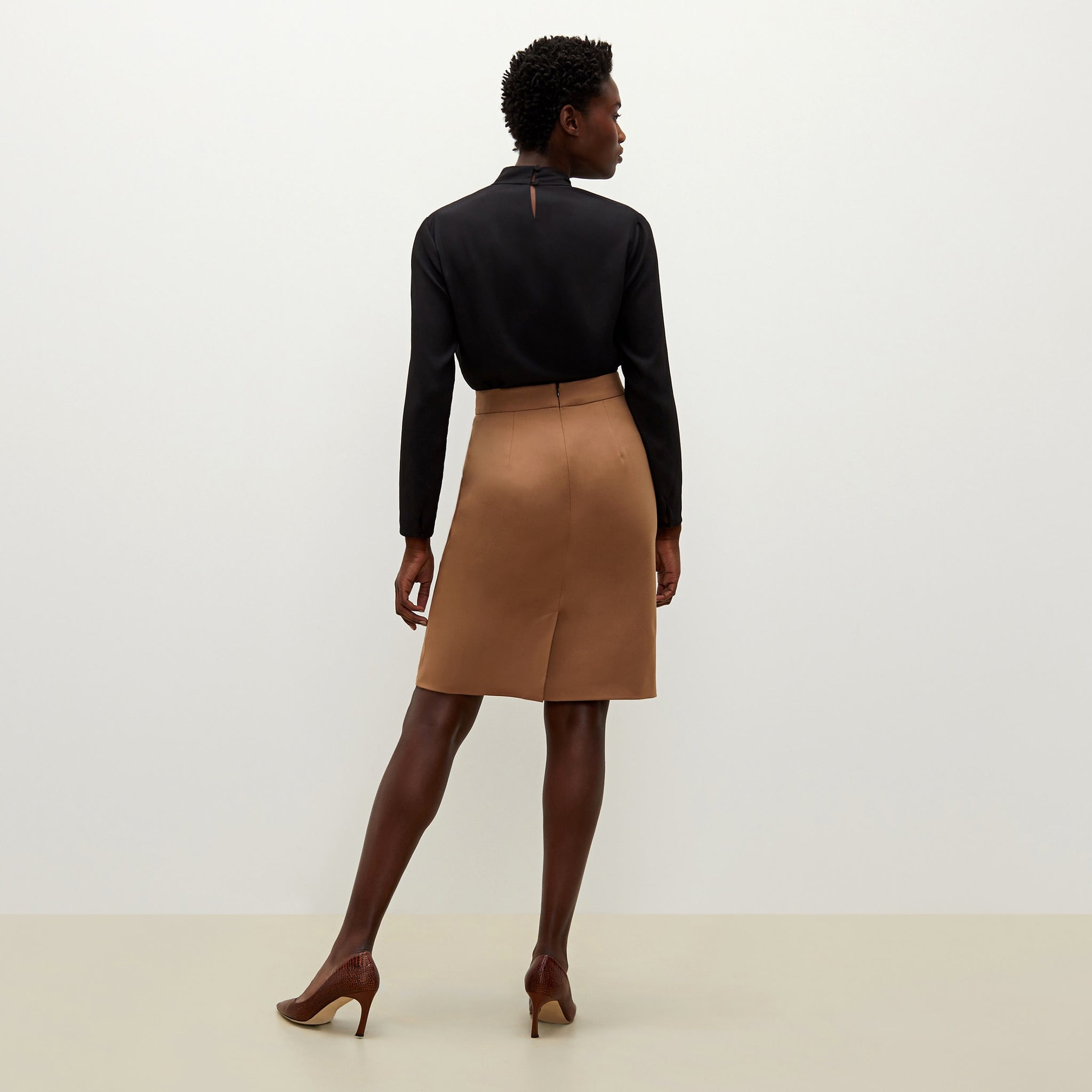 Back image of a woman standing wearing the antoinette top in black