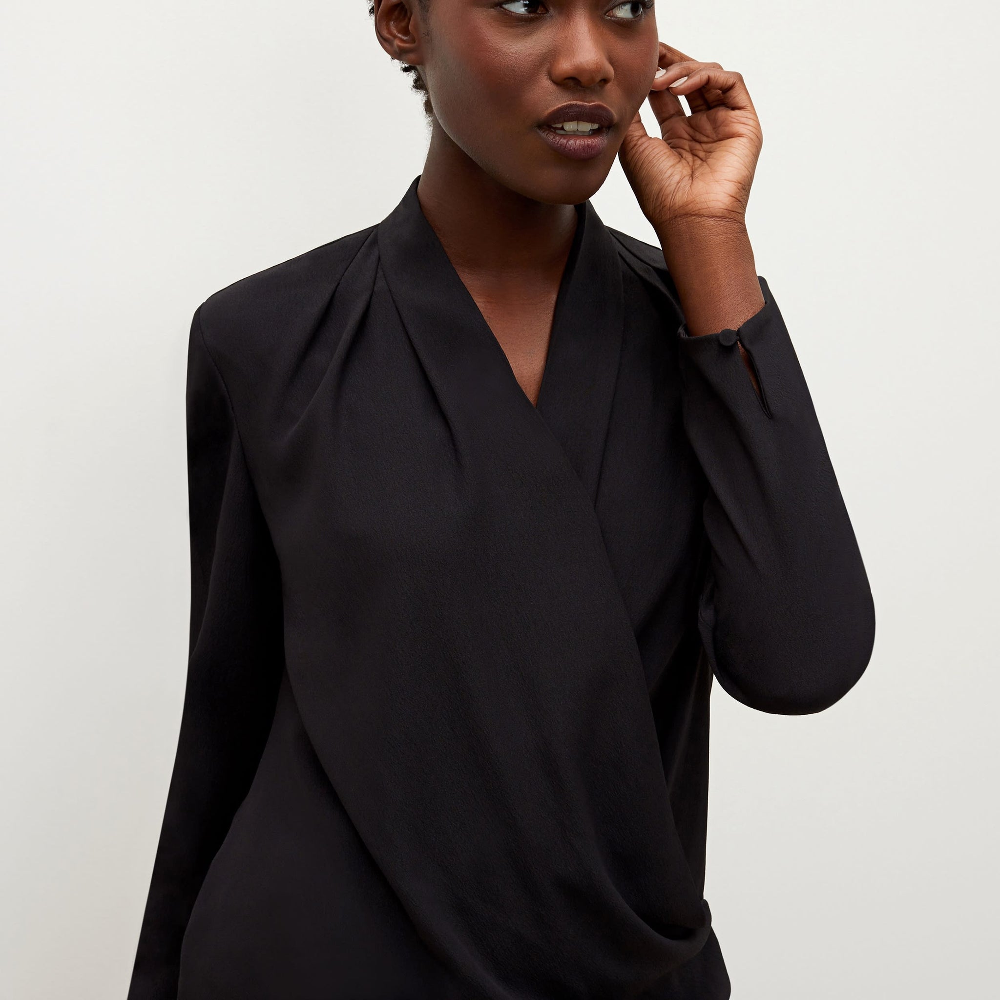 Detail image of a woman standing wearing the antoinette top in black