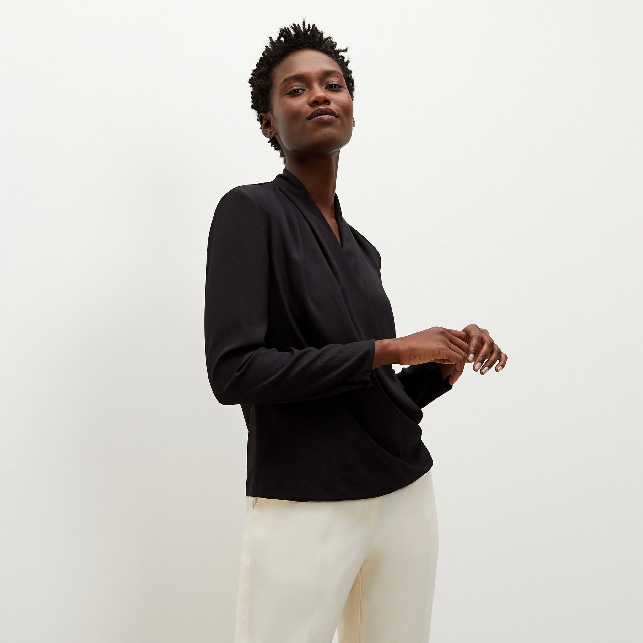 Side image of a woman standing wearing the antoinette top in black