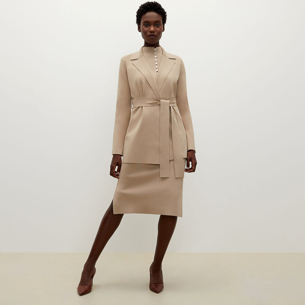 Front image of a woman standing wearing the Malki top in latte