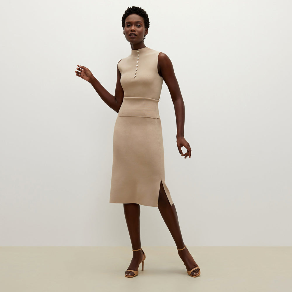 Side image of a woman standing wearing the Malki top in latte