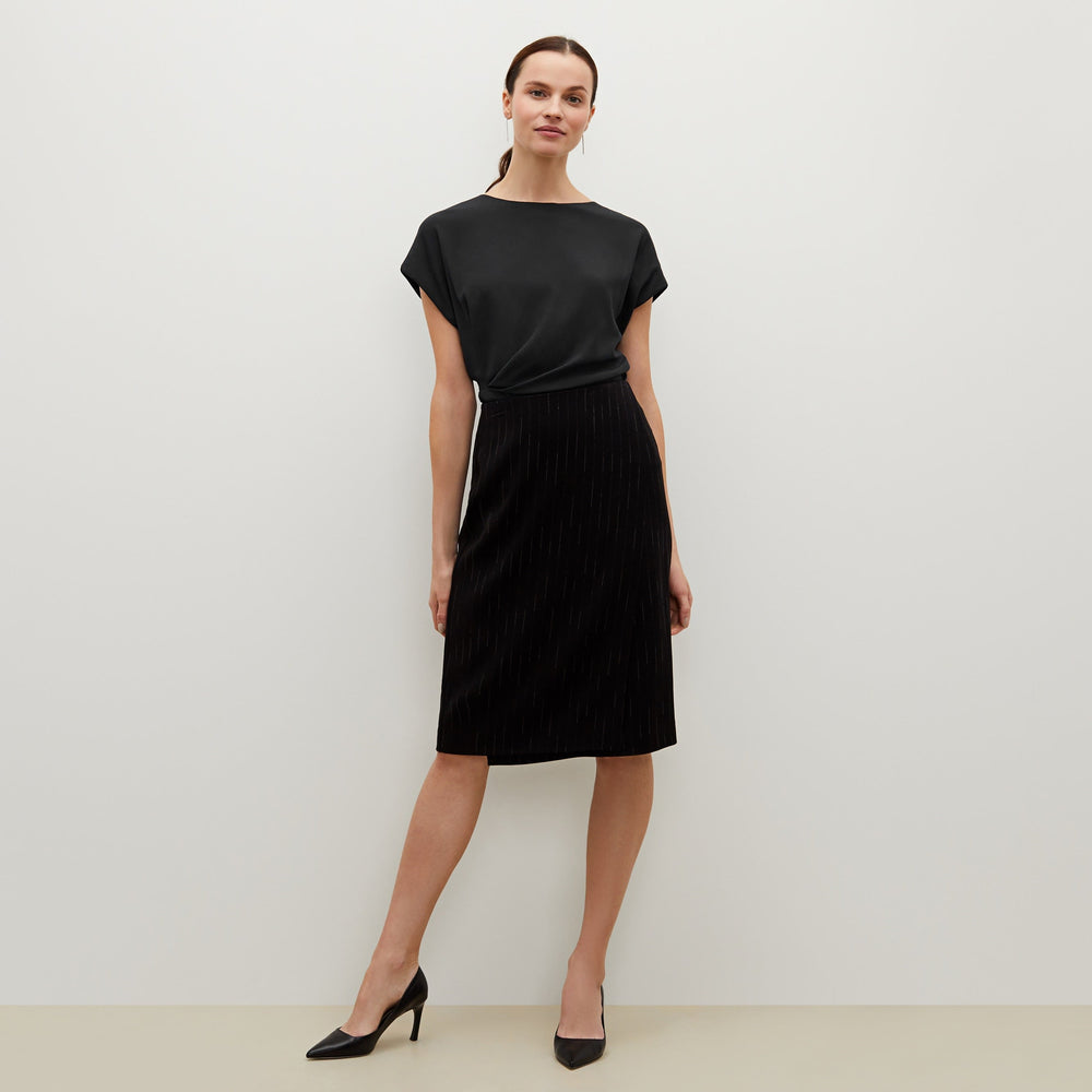 Front image of a woman standing wearing the Nejvi top in black