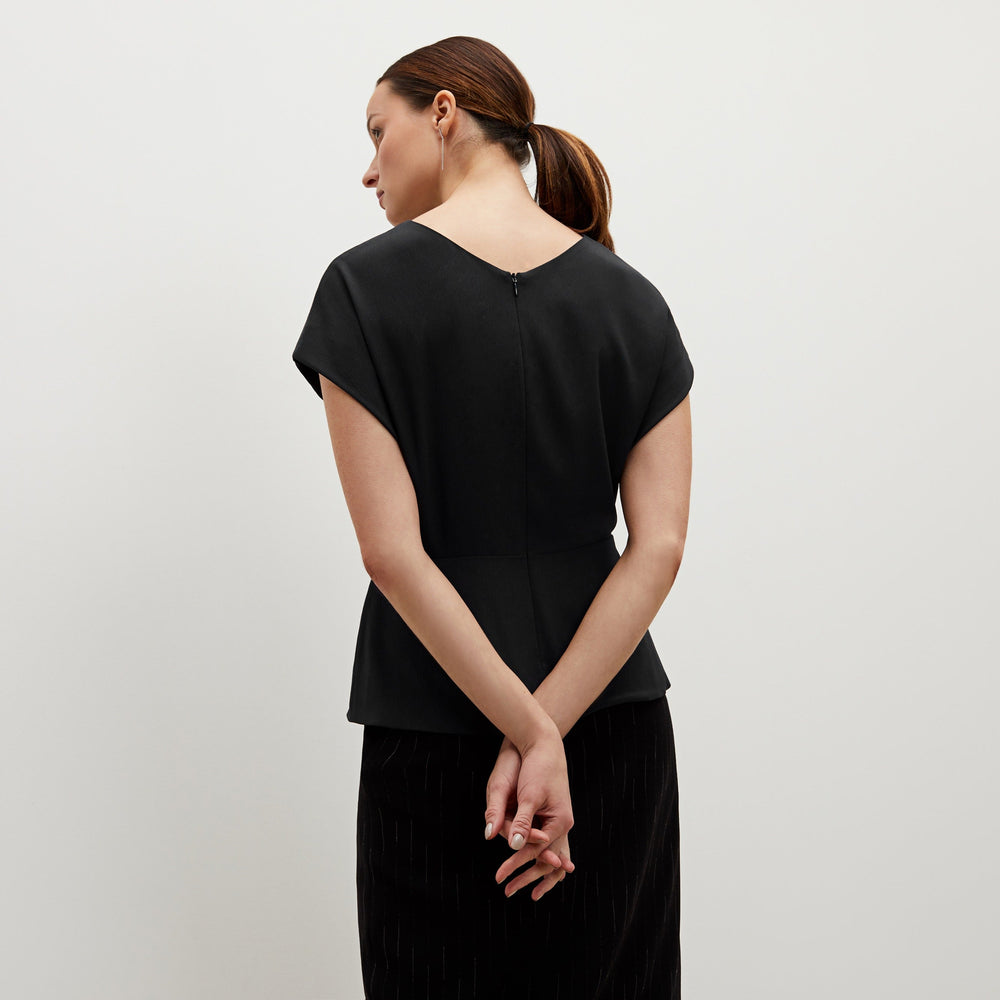 Front image of a woman standing wearing the Nejvi top in black