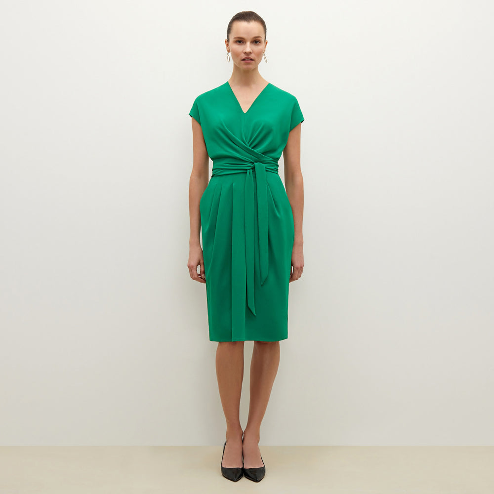Front image of a woman standing wearing the Noel dress in emerald