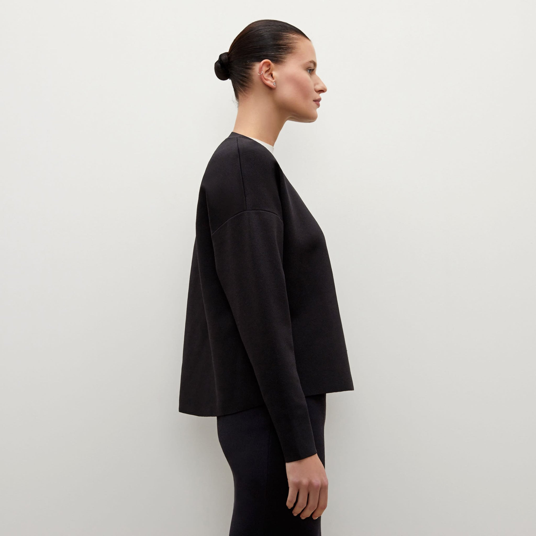 Side image of a woman standing wearing the Para pullover in Black