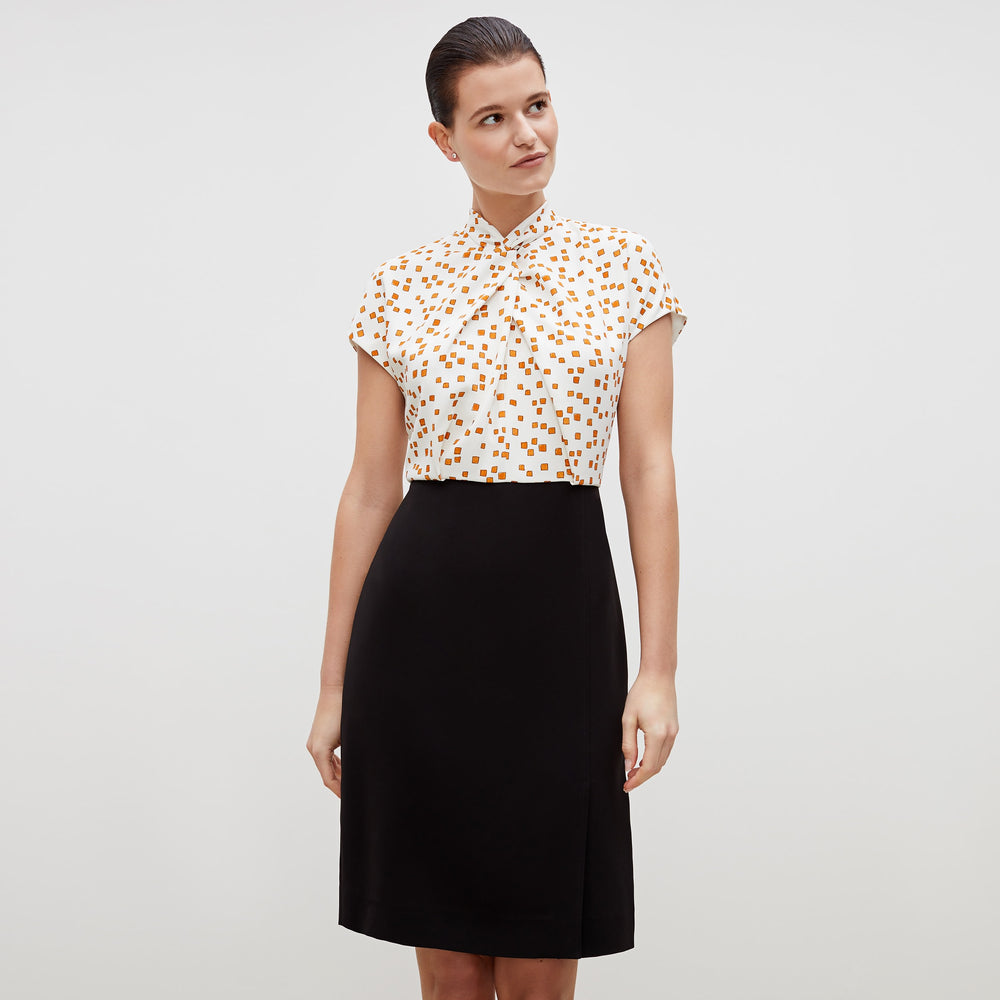 Front image of a woman standing wearing the adelaide dress in mosaic print in goldenrod and ivory