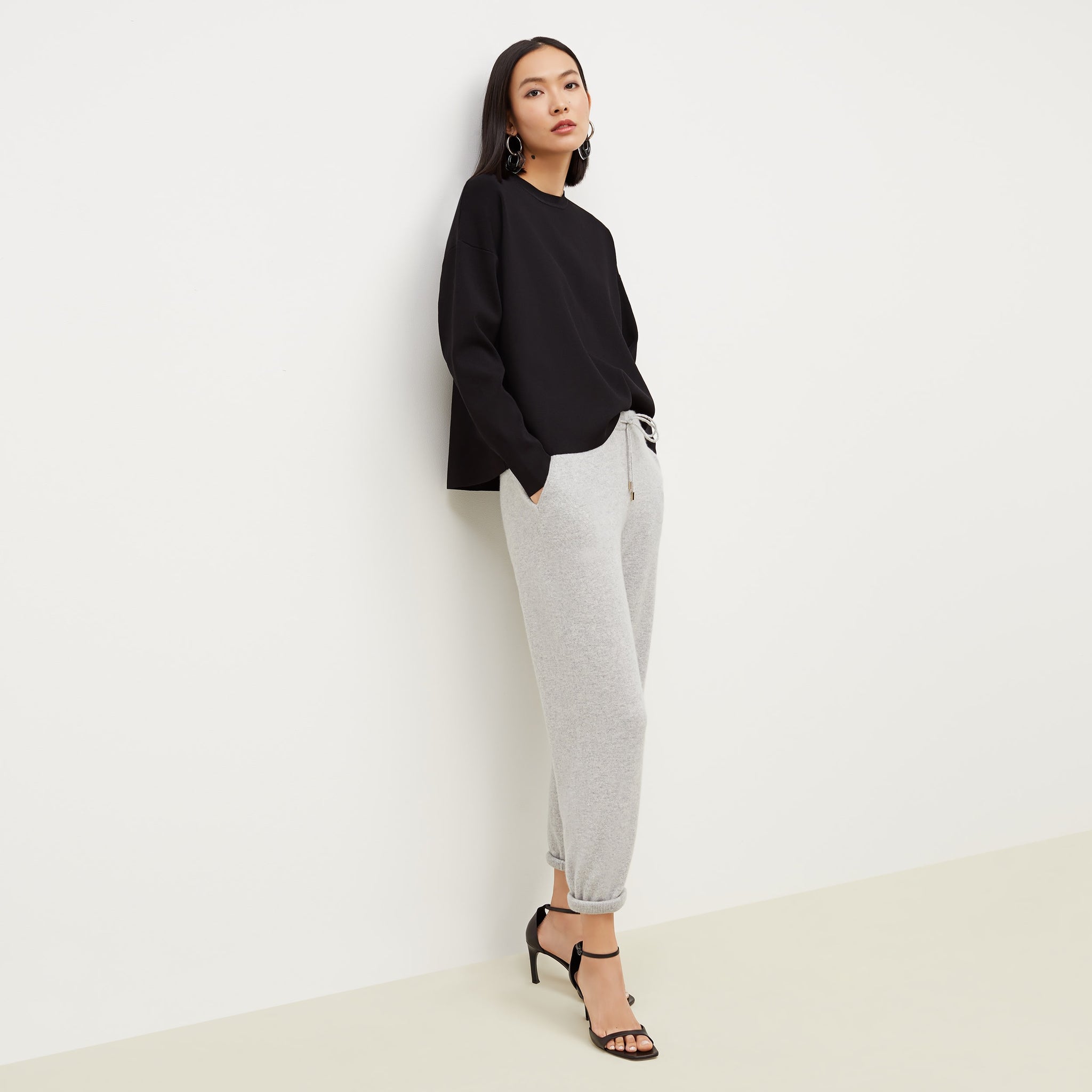 Side image of a woman standing wearing the Para pullover in Black