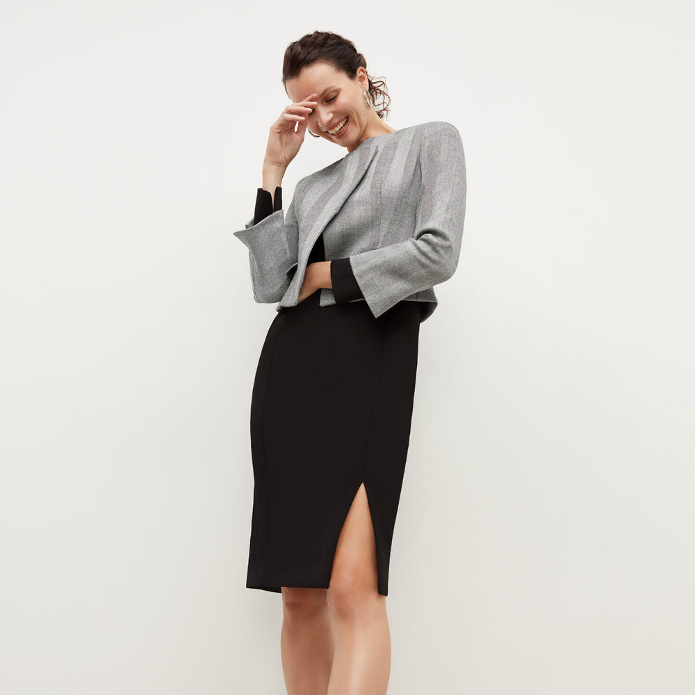 Front image of a woman standing wearing the Joanna Dress-Worth in Black