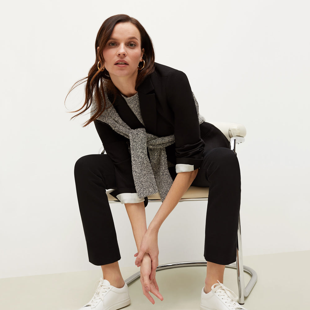 Front image of a woman sitting wearing the Barbara Sweater—Knit Boucle in Black / White