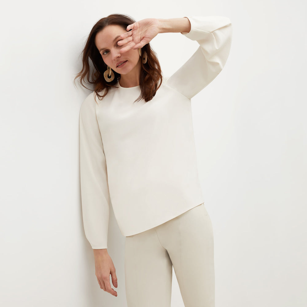 Front image of a woman standing wearing the Carrie Top—Soft Wave in Alabaster
