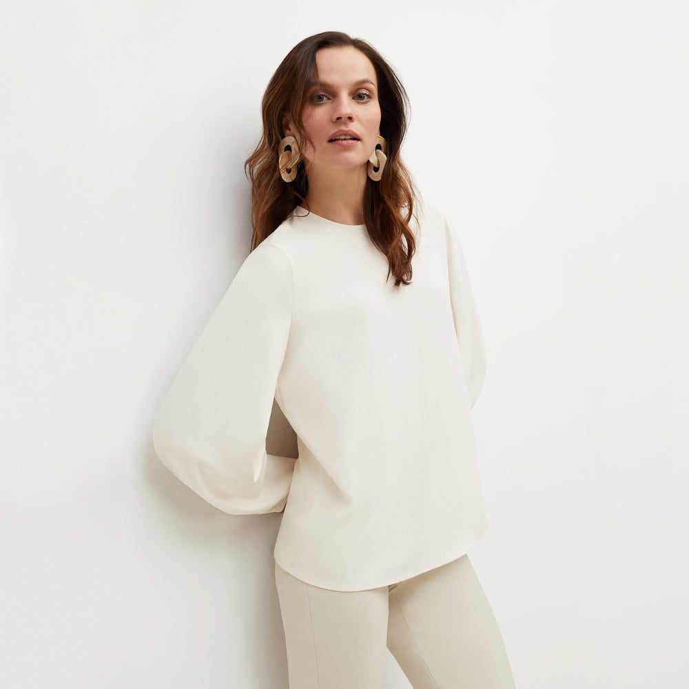 Front image of a woman standing wearing the Carrie Top—Soft Wave in Alabaster