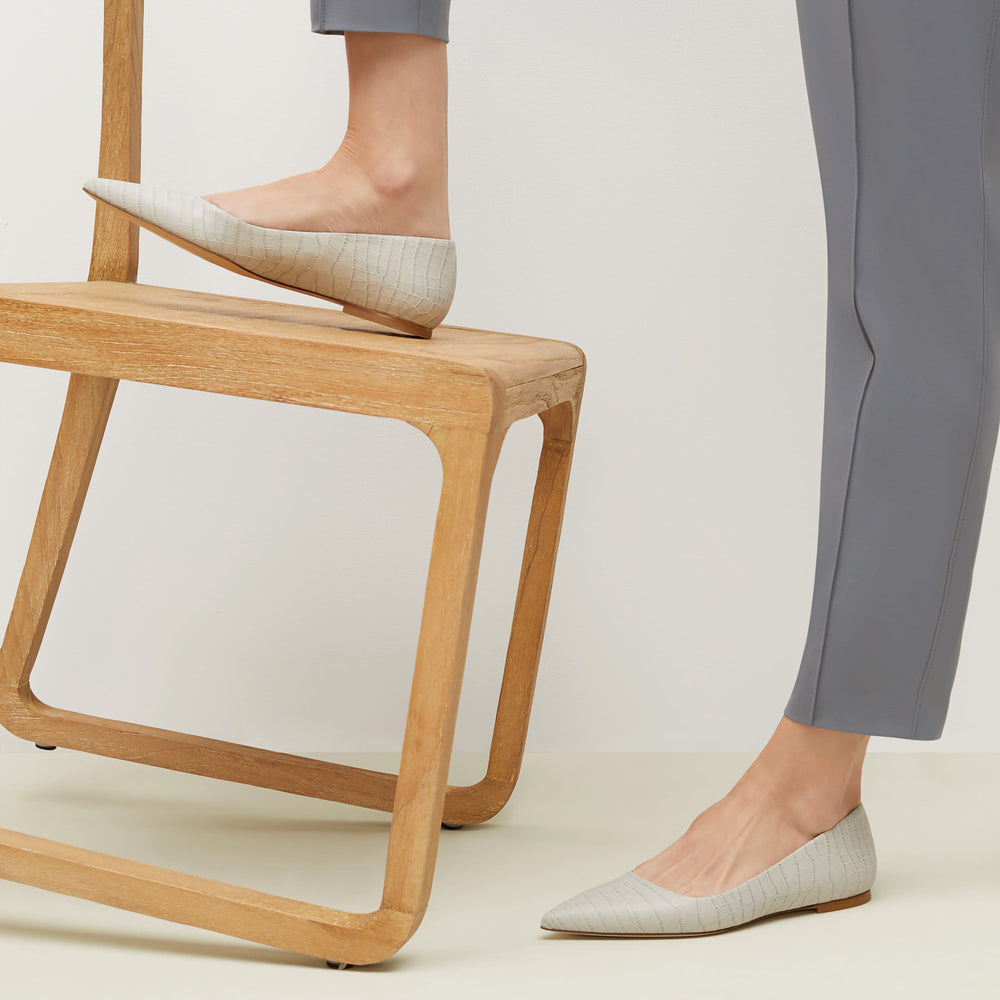 Side image of a woman standing wearing the Rowan Flat—Embossed Croc in Gray