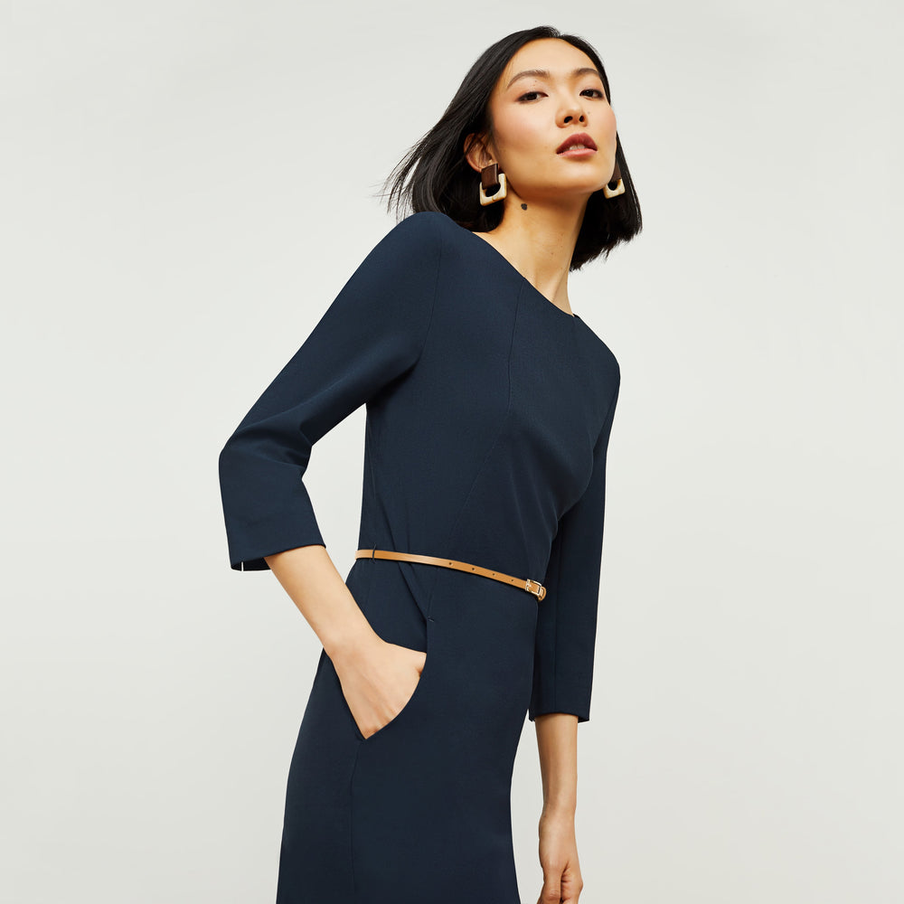 Side image of a woman standing wearing the Etsuko Dress—Recycled WonderTex in Midnight