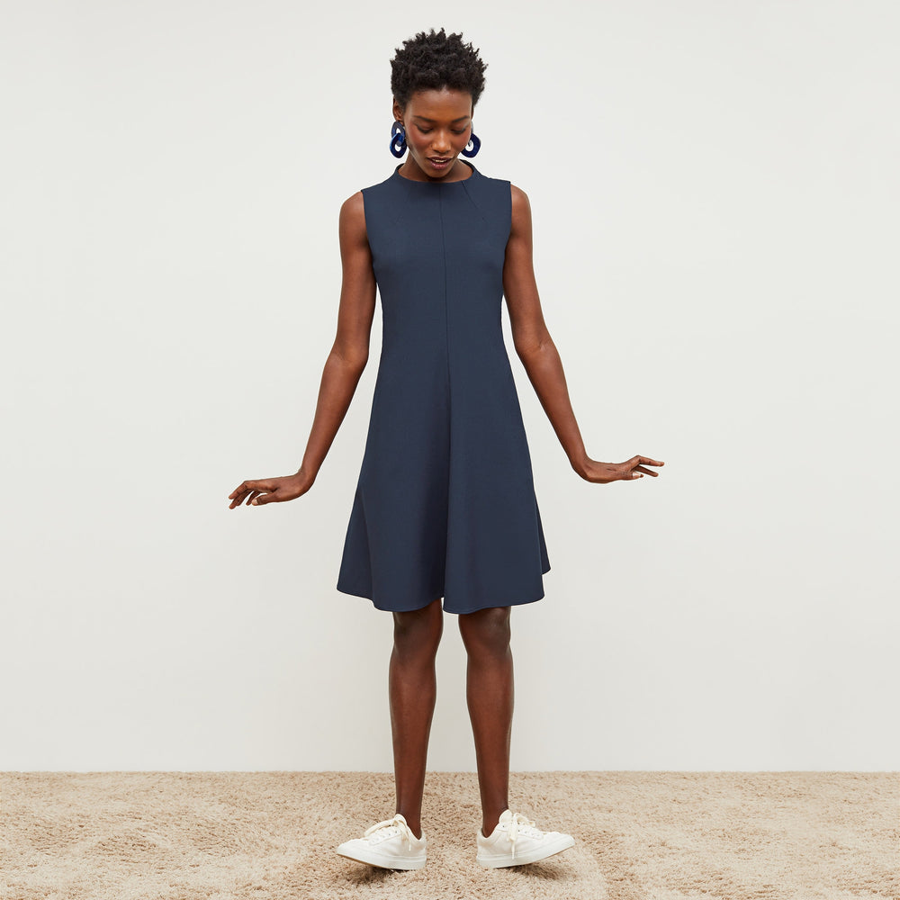 Front image of a woman standing wearing the Malala Dress—Recycled WonderTex in Midnight