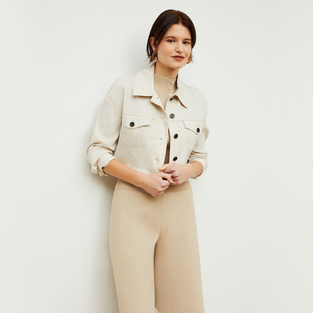 Front image of a woman standing wearing the Malki top in latte