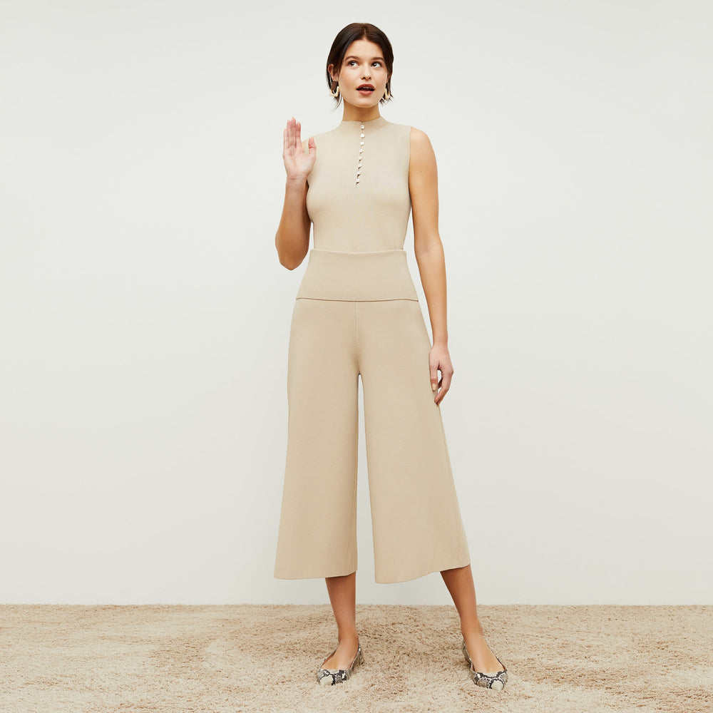 Front image of a woman standing wearing the Malki top in latte