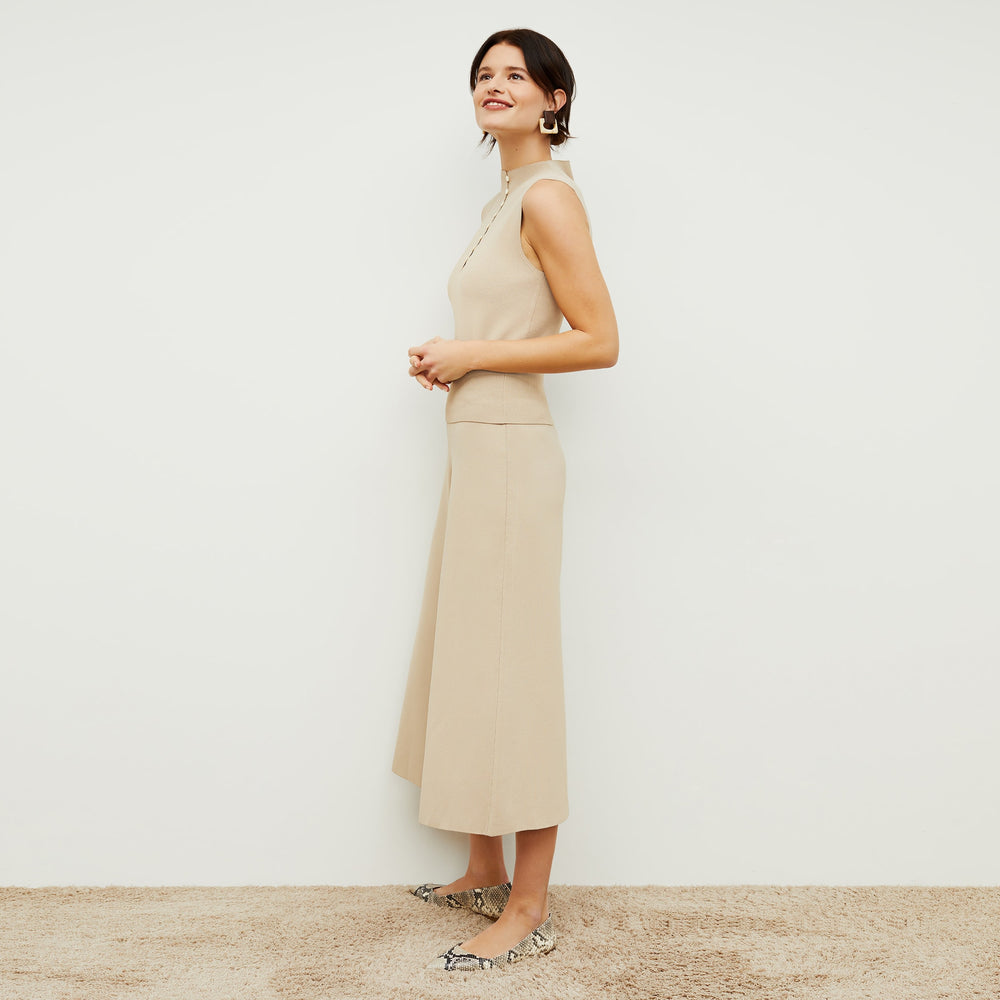 Side image of a woman standing wearing the Malki top in latte