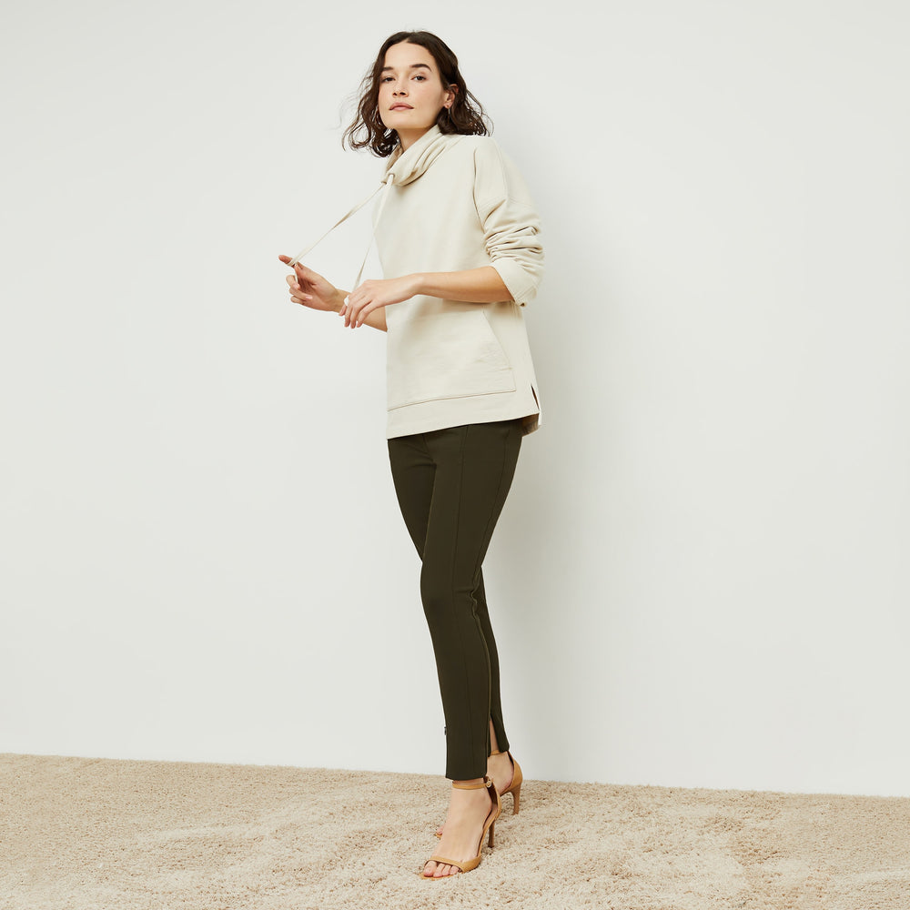 Side image of a woman standing wearing the curie pant in dark olive