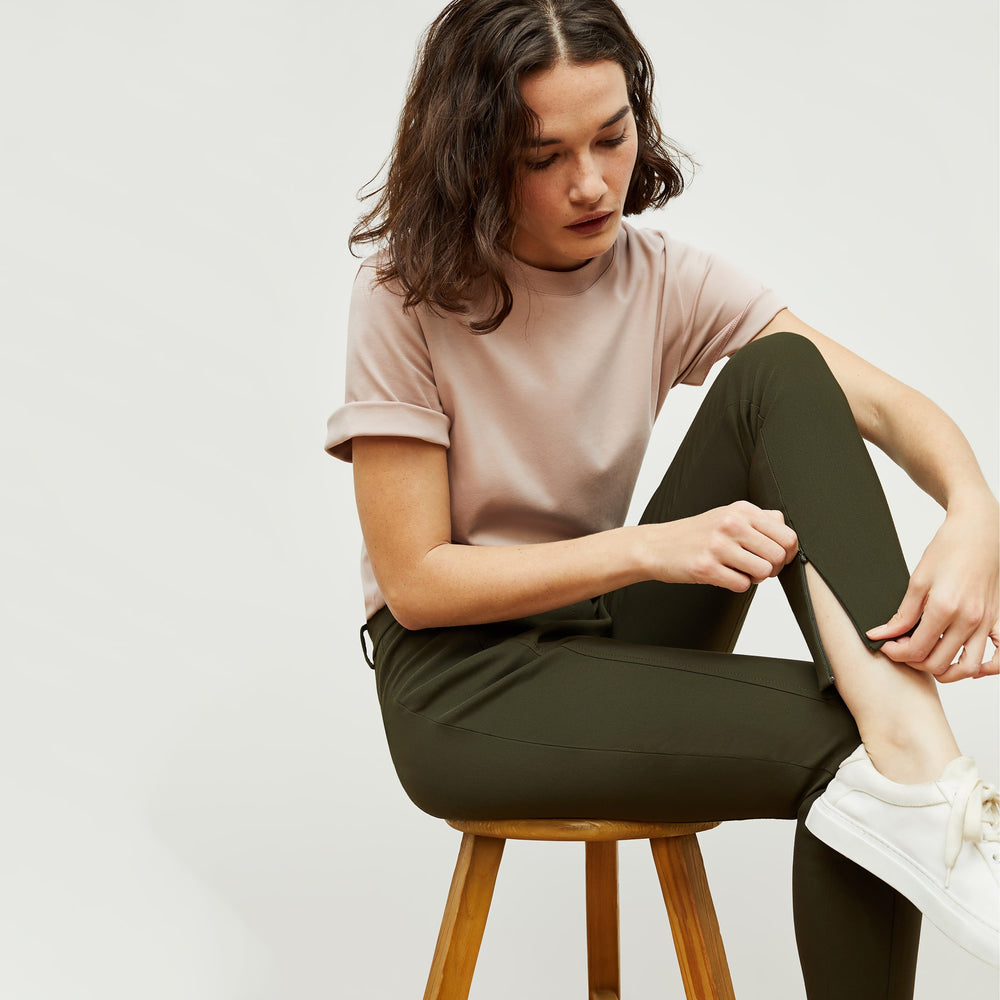 Detail image of a woman standing wearing the curie pant in dark olive