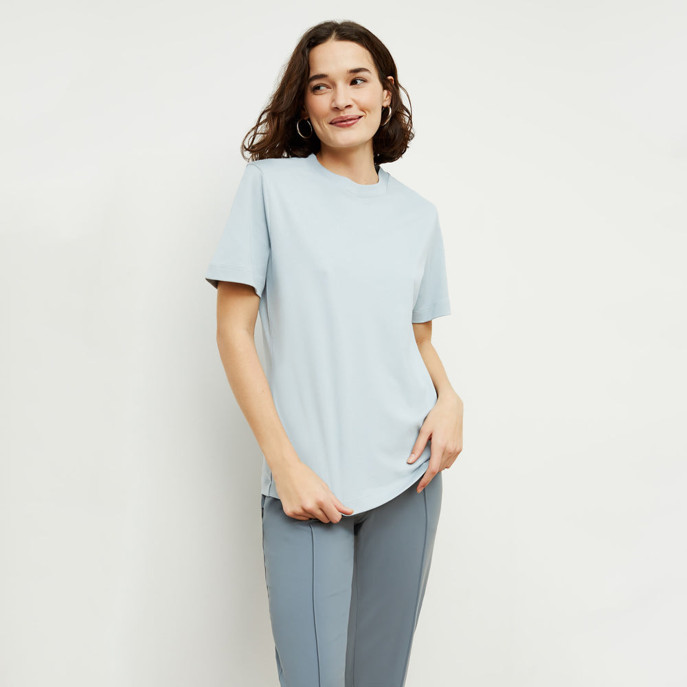 Front image of a woman standing wearing the Leslie T-Shirt—Compact Cotton in Sky Blue