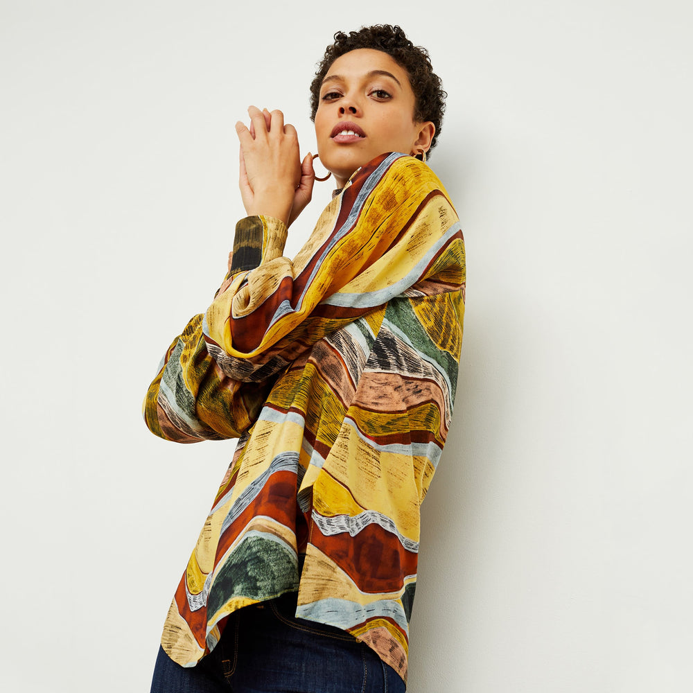 Side image of a woman standing wearing the Fiona Top—Silk Desert in Multicolor