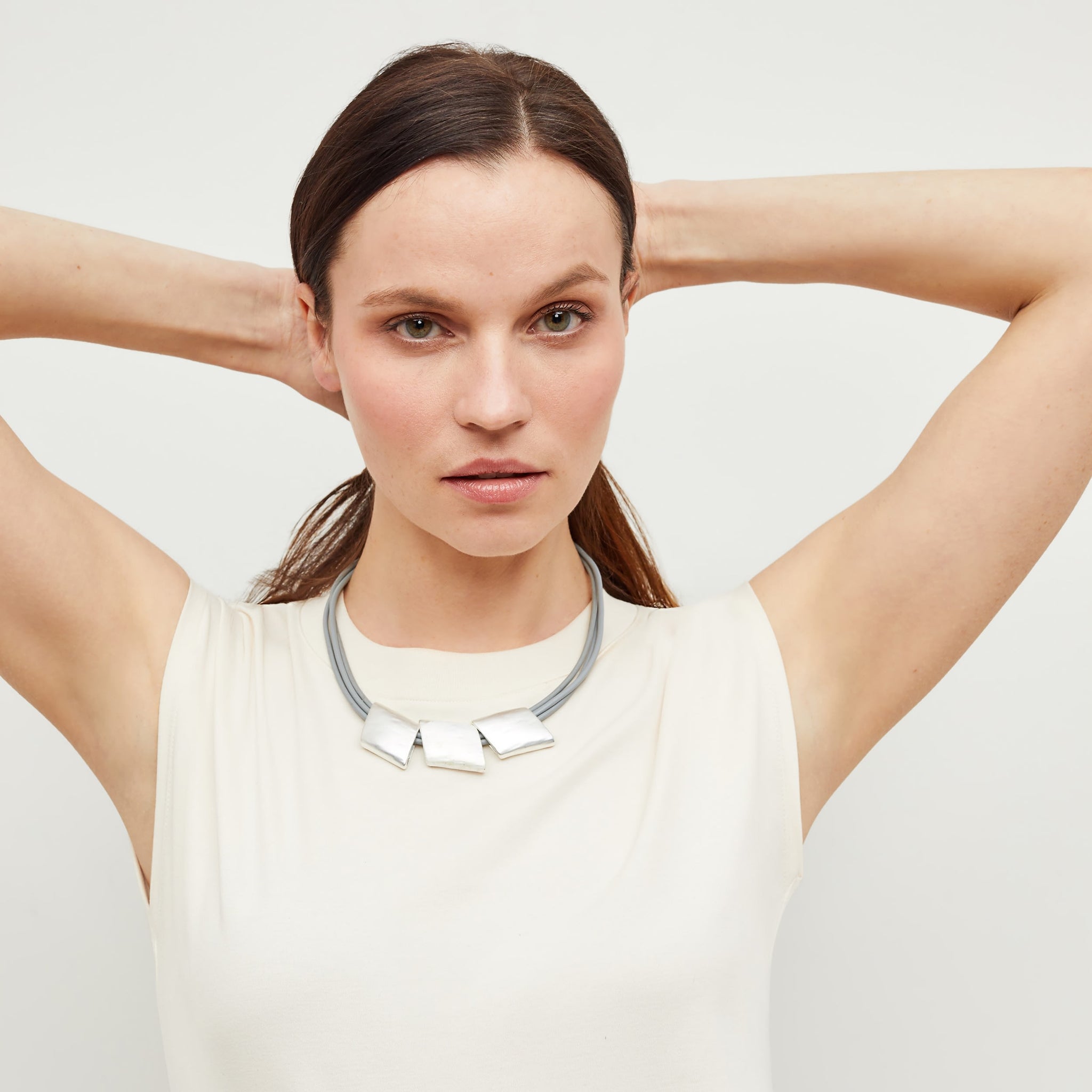Front image of a woman standing wearing the Herma Necklace in Silver