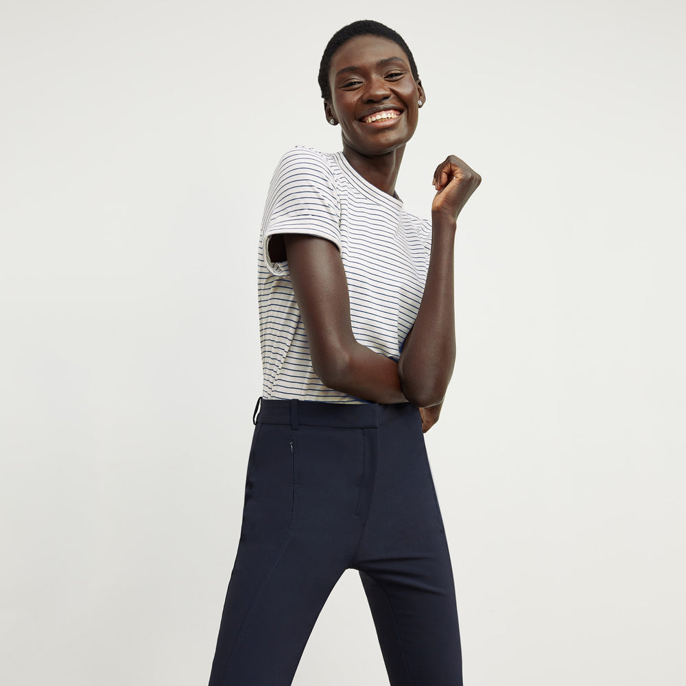 Front image of a woman standing wearing the Leslie T-Shirt—Thin Striped Cotton in Ivory / Coastline