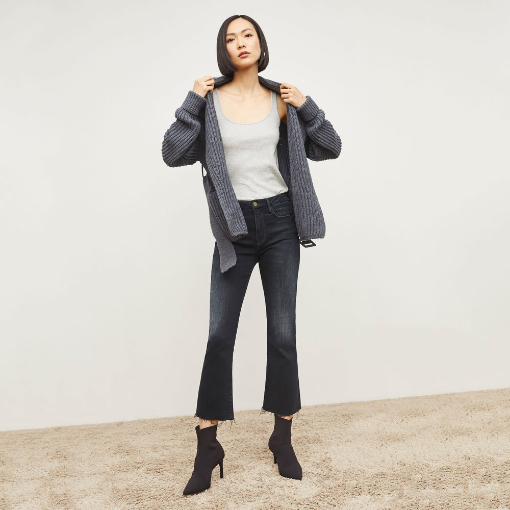 Front image of a woman standing wearing the FRAME Denim Le Crop Slim Bootcut Raw Edge Jean in Marcella