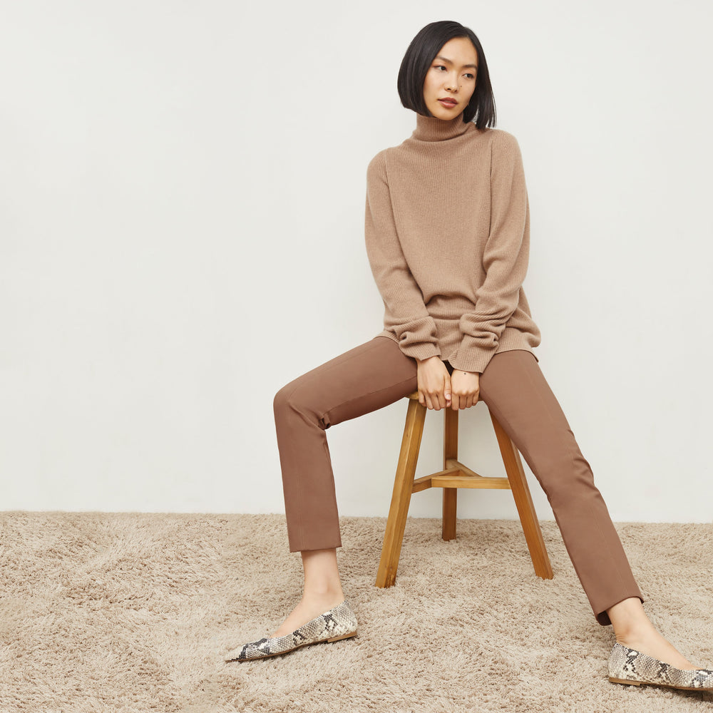 Front image of a woman sitting wearing the Foster Pant—Everstretch in Saddle