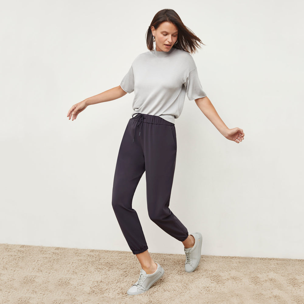Front image of a woman standing wearing the mia top in silk jersey in pale gray