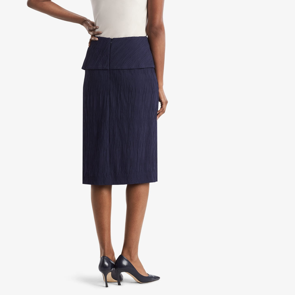 Back image of a woman standing wearing the Montgomery Skirt in aegean blue