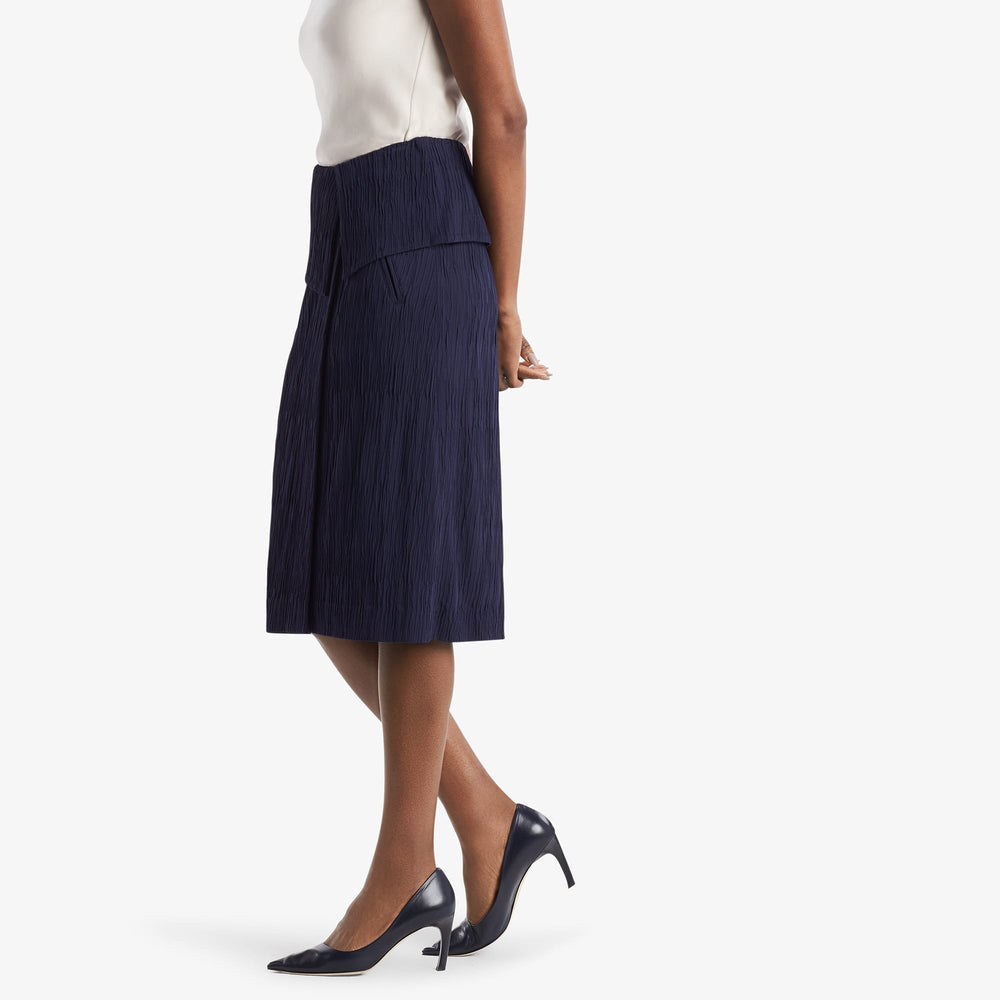 Side image of a woman standing wearing the Montgomery Skirt in aegean blue