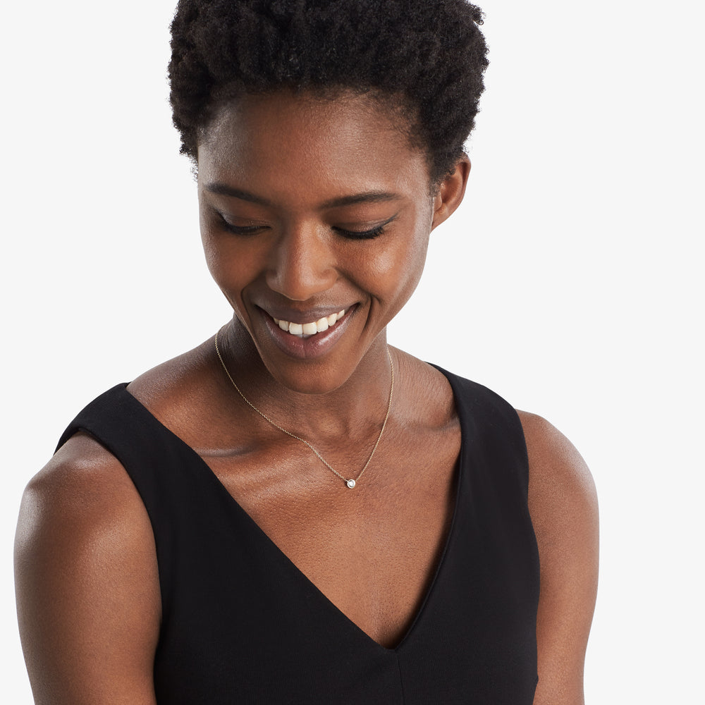 image of a woman wearing the single bezel necklace in gold