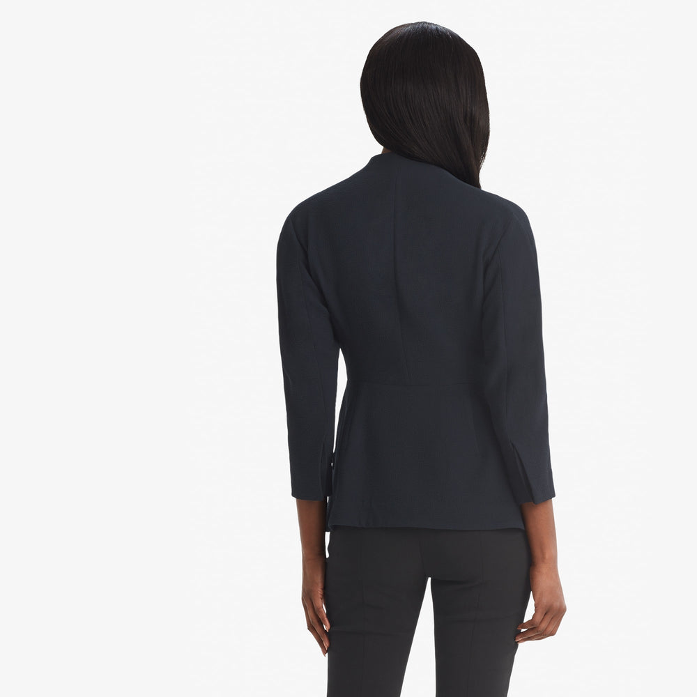 Back image of a woman standing wearing the Higgins jacket staccato in galaxy blue