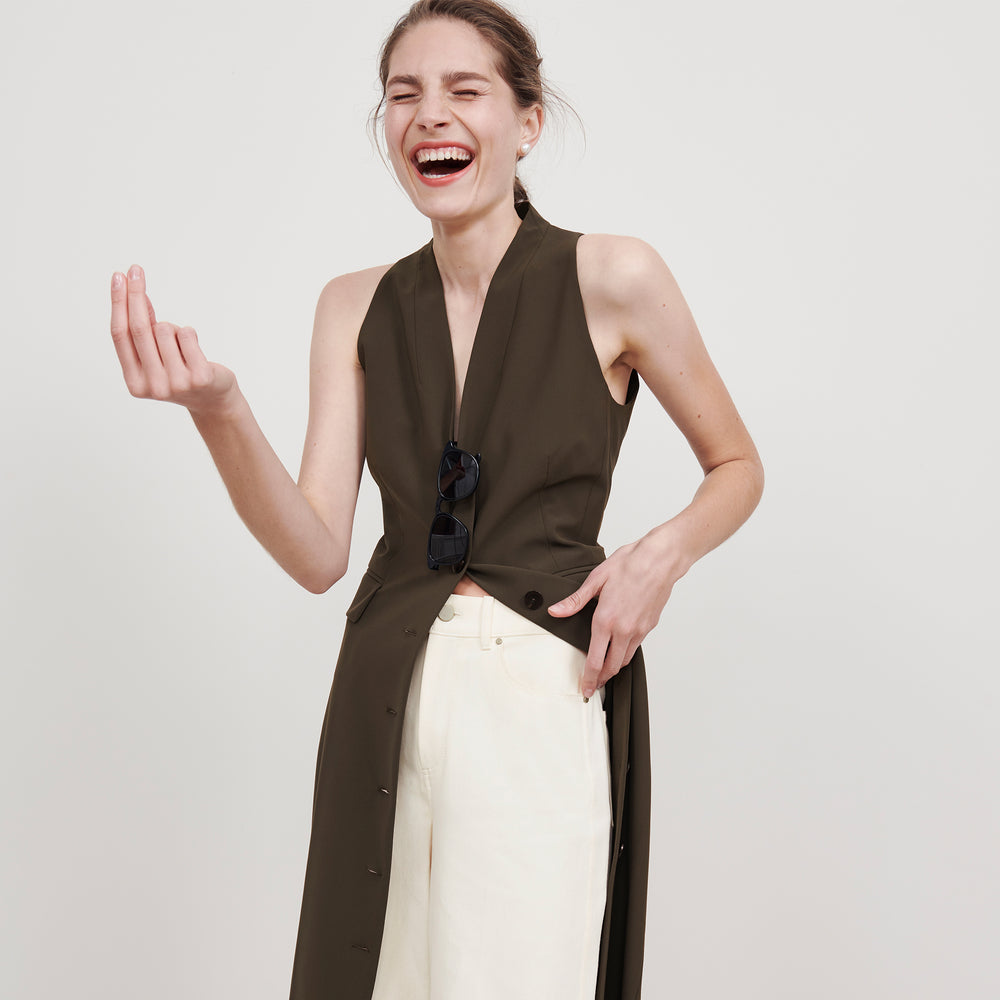 Front image of a woman wearing the Cassandra dress in origamitech in olive