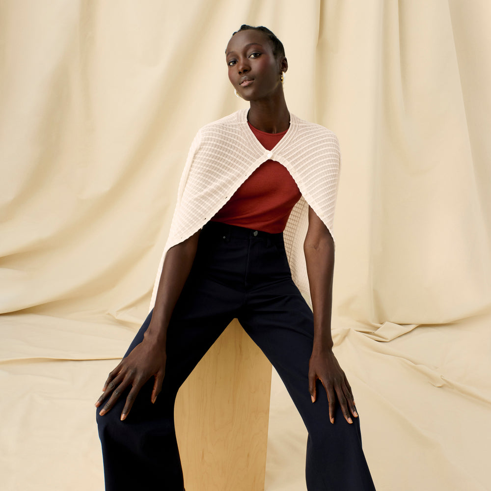 Front image of a woman sitting wearing the Emerson Cardigan in Meringue