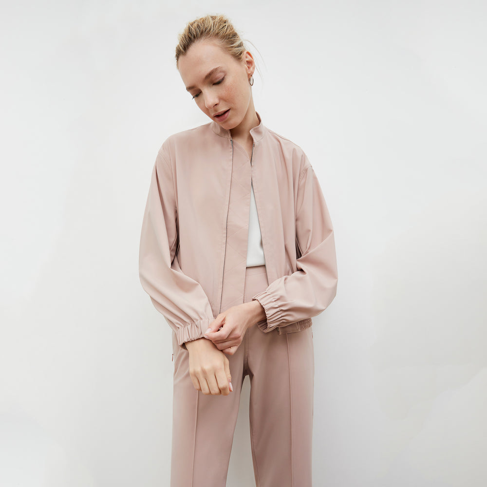 Front image of a woman wearing the Langely Bomber in Origamitech in Blush