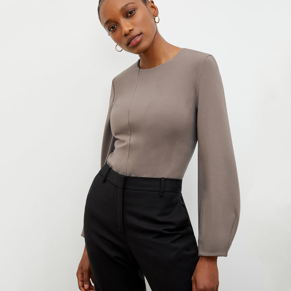 Front image of a woman wearing the Rashida top in Pebble
